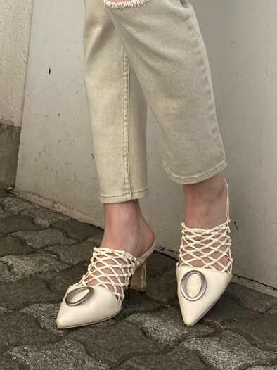 グリーン系のカーディガン/ボレロ、ホワイト系のパンプス、ゴールド系のイヤリングを着用したレディースの冬コーディネートの5枚目の写真