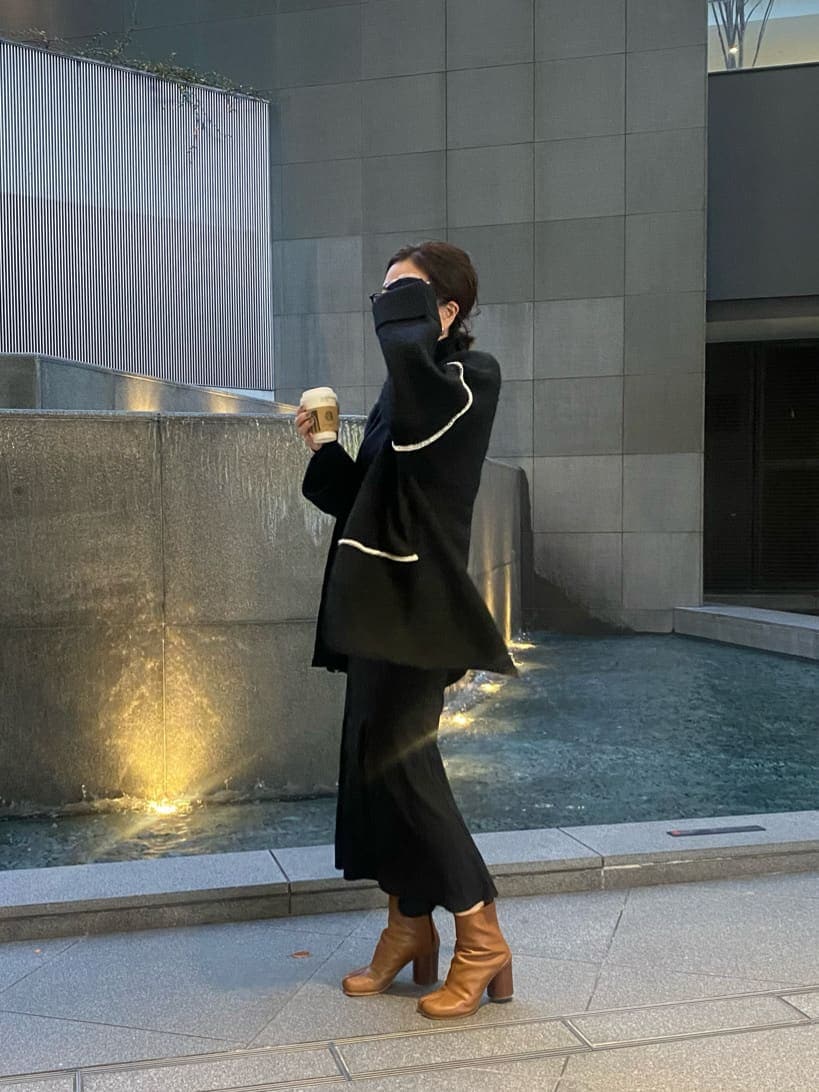 ブラック系のニット/セーター、ブラック系のスカート、ブラック系のカーディガン/ボレロを着用したレディースの冬コーディネートの4枚目の写真