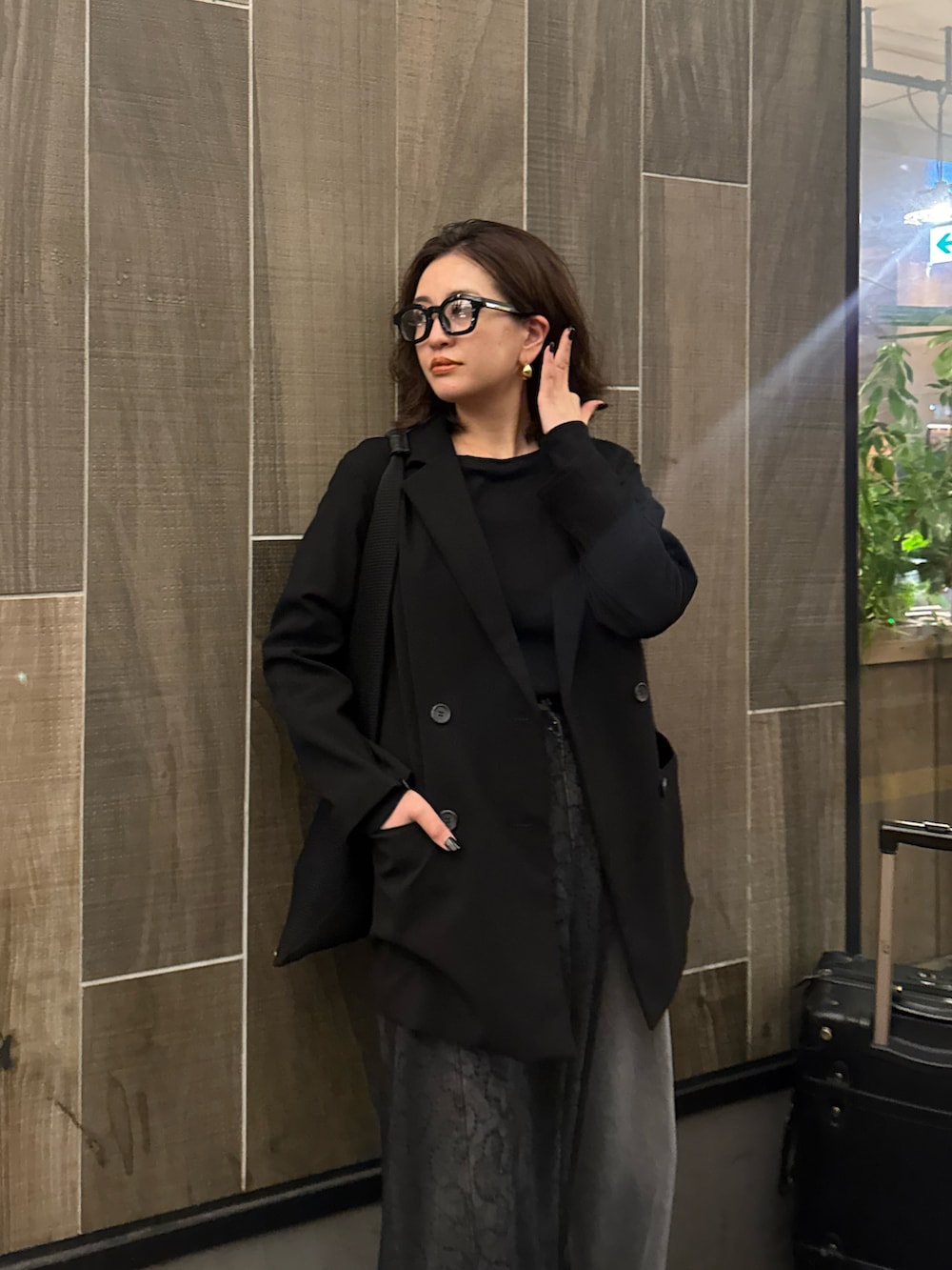 ブラック系のテーラードジャケット、ブラック系のデニムパンツ、ブラック系のストール/ショールを着用したレディースの春コーディネートの4枚目の写真