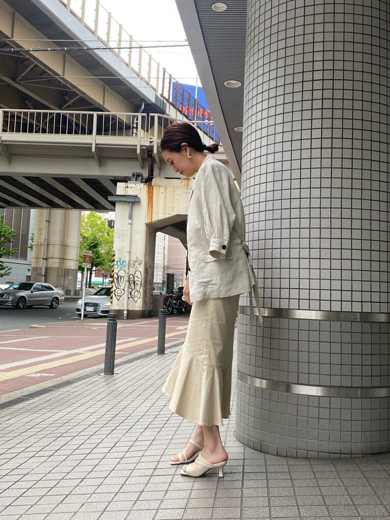 ホワイト系のサンダル、ホワイト系のスカート、グリーン系のニット/セーターを着用したレディースの春コーディネートの3枚目の写真