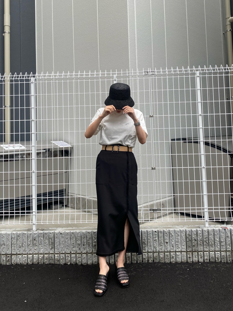 ブラック系のスカート、ブラック系のサンダル、ホワイト系のTシャツ/カットソーを着用したレディースの春コーディネートの4枚目の写真