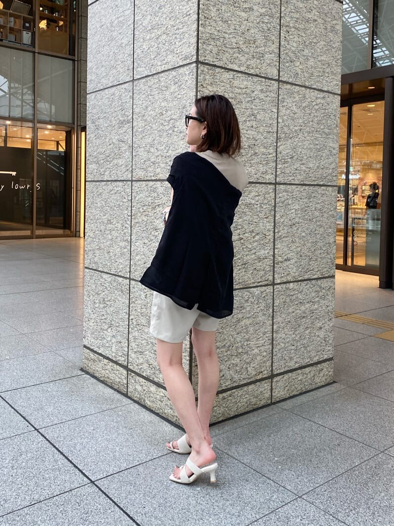 ホワイト系のサンダル、ブラック系のシャツ/ブラウス、ベージュ系のタンクトップを着用したレディースの春コーディネートの3枚目の写真