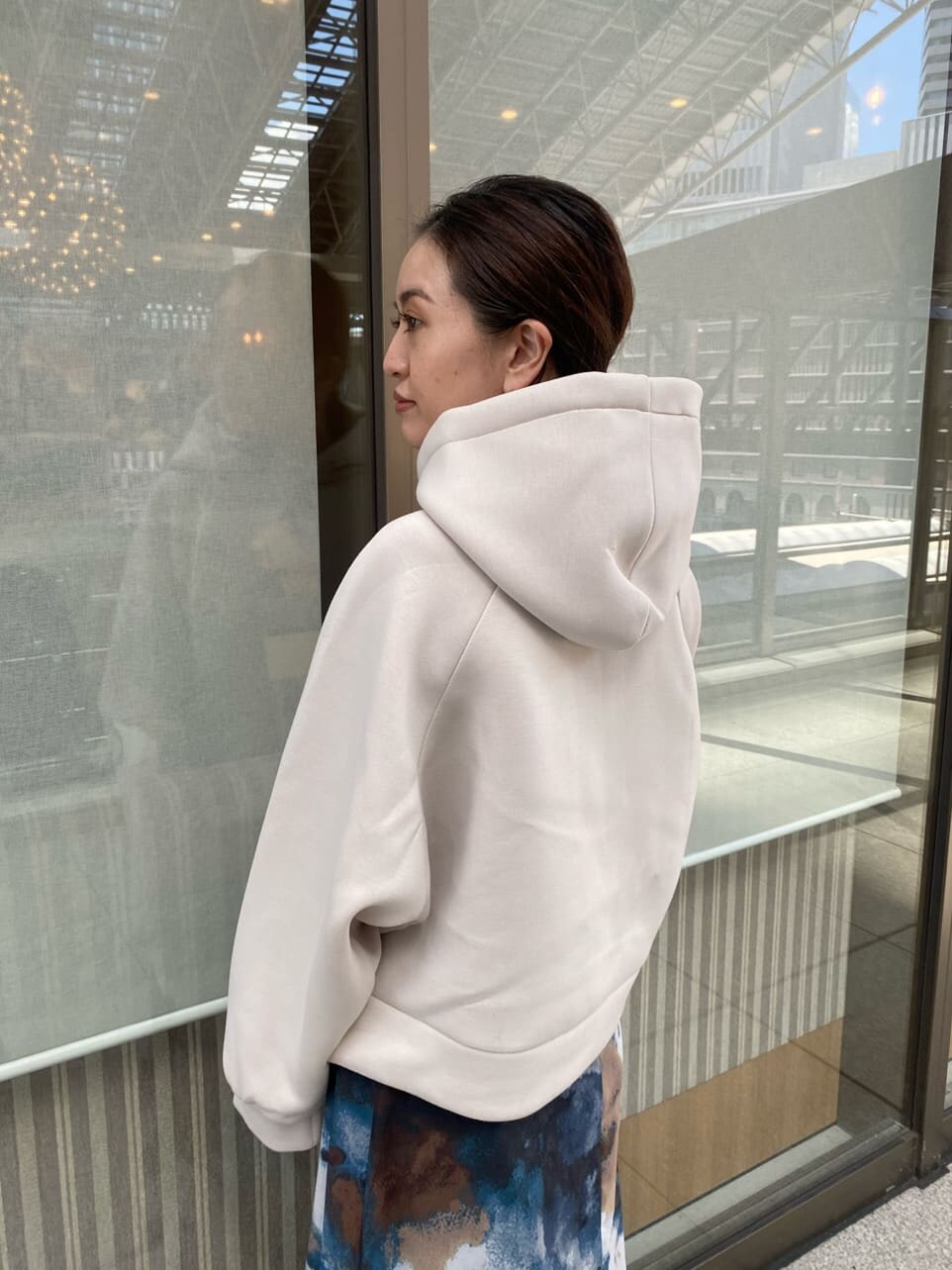 ブルー系のスカート、ブラック系のブーツ、ホワイト系のパーカーを着用したレディースの秋コーディネートの8枚目の写真