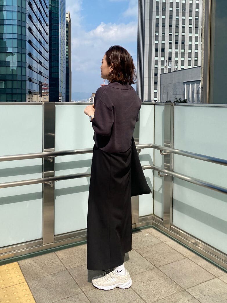 ブラック系のスカート、グレー系のニット/セーター、ブラック系のハットを着用したレディースの春コーディネートの5枚目の写真