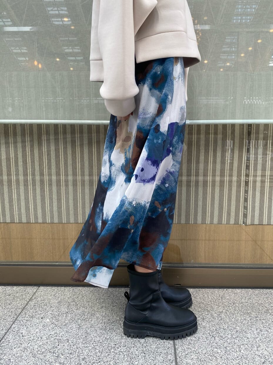 ブルー系のスカート、ブラック系のブーツ、ホワイト系のパーカーを着用したレディースの秋コーディネートの6枚目の写真