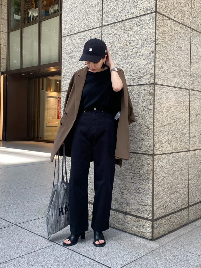 ブラック系のデニムパンツ、ブラック系のサンダルを着用したレディースの春コーディネートの4枚目の写真