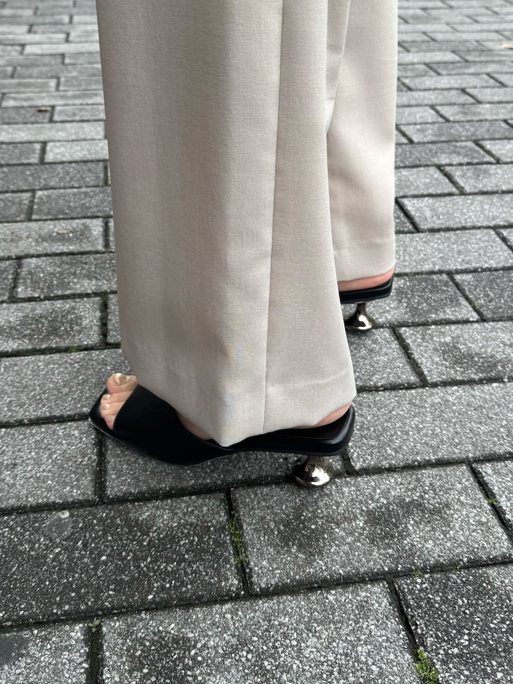 ベージュ系のその他パンツ、ベージュ系のベスト、ブラック系のサンダルを着用したレディースの春コーディネートの6枚目の写真