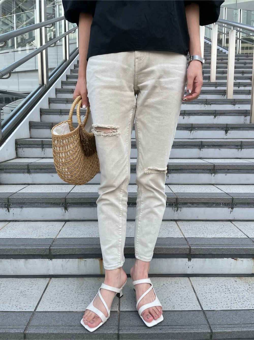 ブラック系のシャツ/ブラウス、ベージュ系のかごバッグ、グレー系のデニムパンツを着用したレディースの夏コーディネートの7枚目の写真