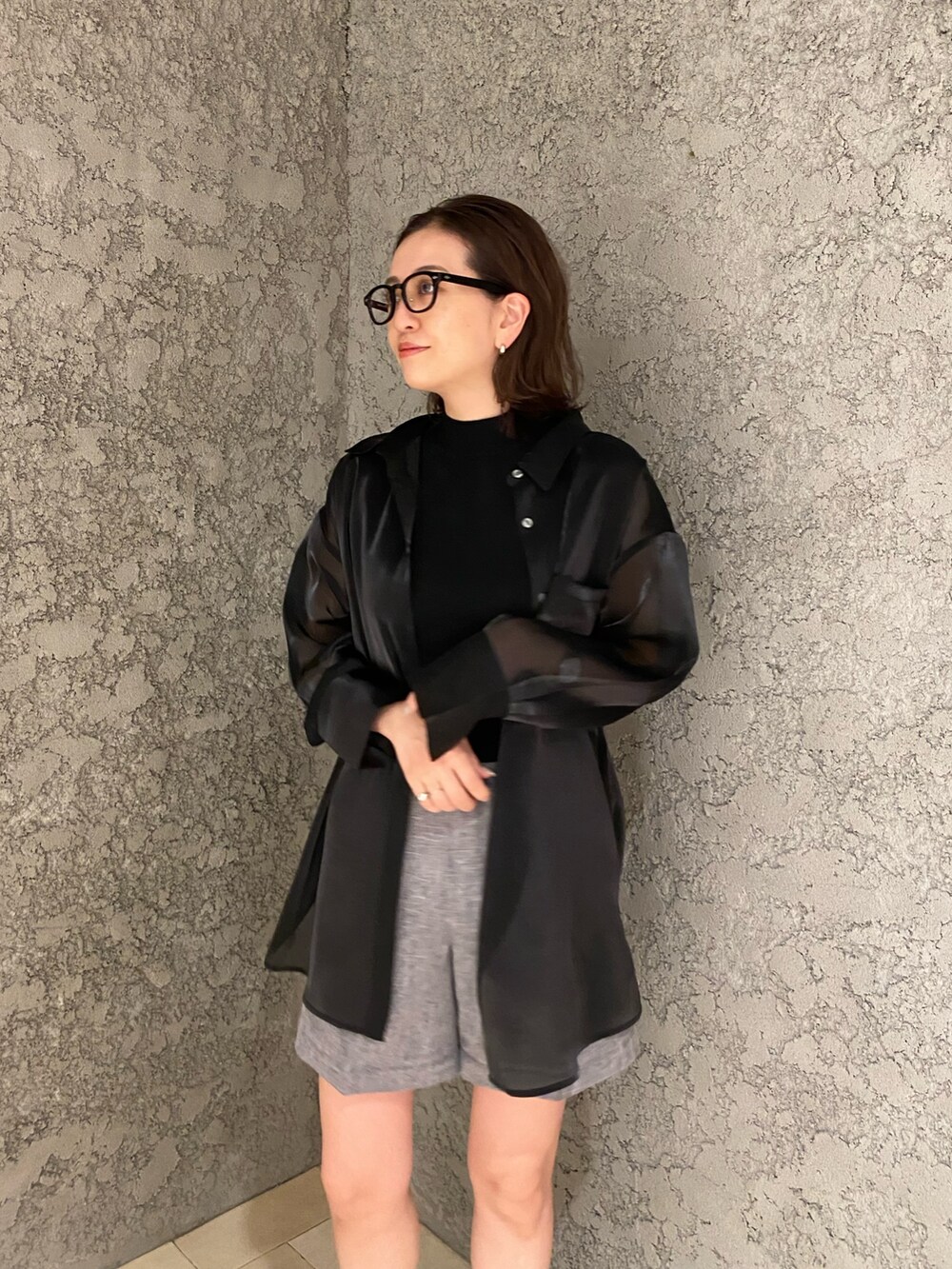 グレー系のスラックス、ブラック系のシャツ/ブラウス、ブラック系のニット/セーターを着用したレディースの春コーディネートの5枚目の写真