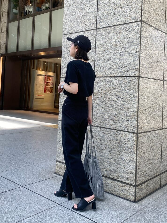 ブラック系のデニムパンツ、ブラック系のサンダルを着用したレディースの春コーディネートの3枚目の写真