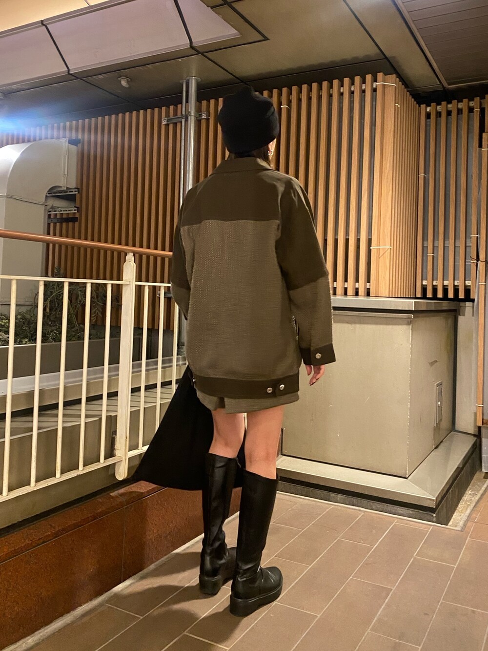 グリーン系のブルゾン、グリーン系のカーゴパンツ、ブラック系のニット/セーターを着用したレディースの冬コーディネートの3枚目の写真