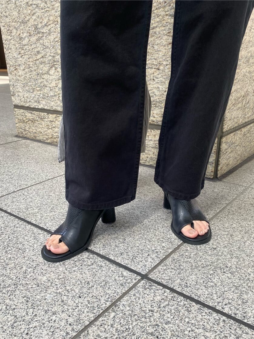 ブラック系のデニムパンツ、ブラック系のサンダルを着用したレディースの春コーディネートの8枚目の写真