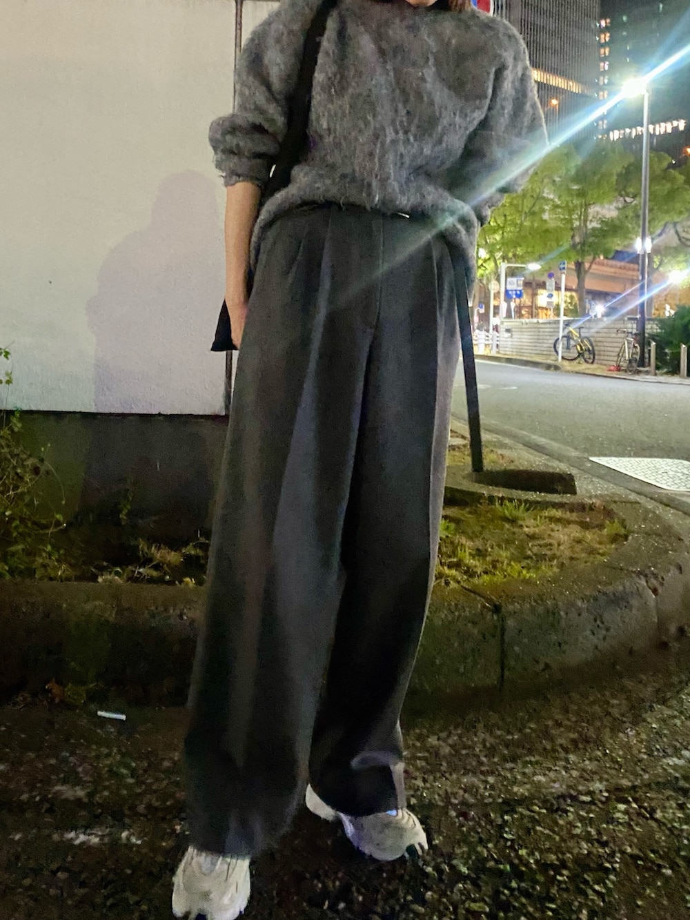 グレー系のスラックス、グレー系のニット/セーターを着用したレディースの冬コーディネートの6枚目の写真
