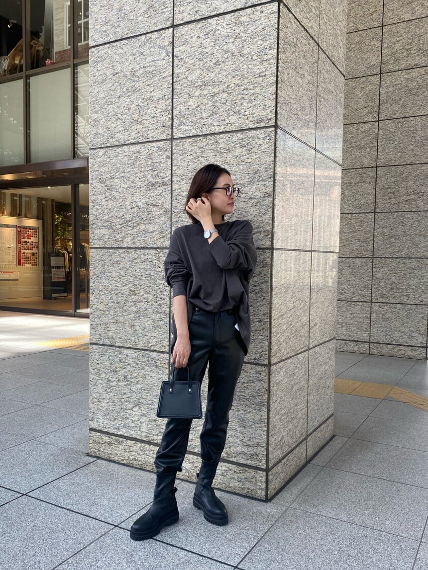 ブラック系のブーツ、ブラック系のハンドバッグ、グレー系のTシャツ/カットソーを着用したレディースの秋コーディネートの2枚目の写真