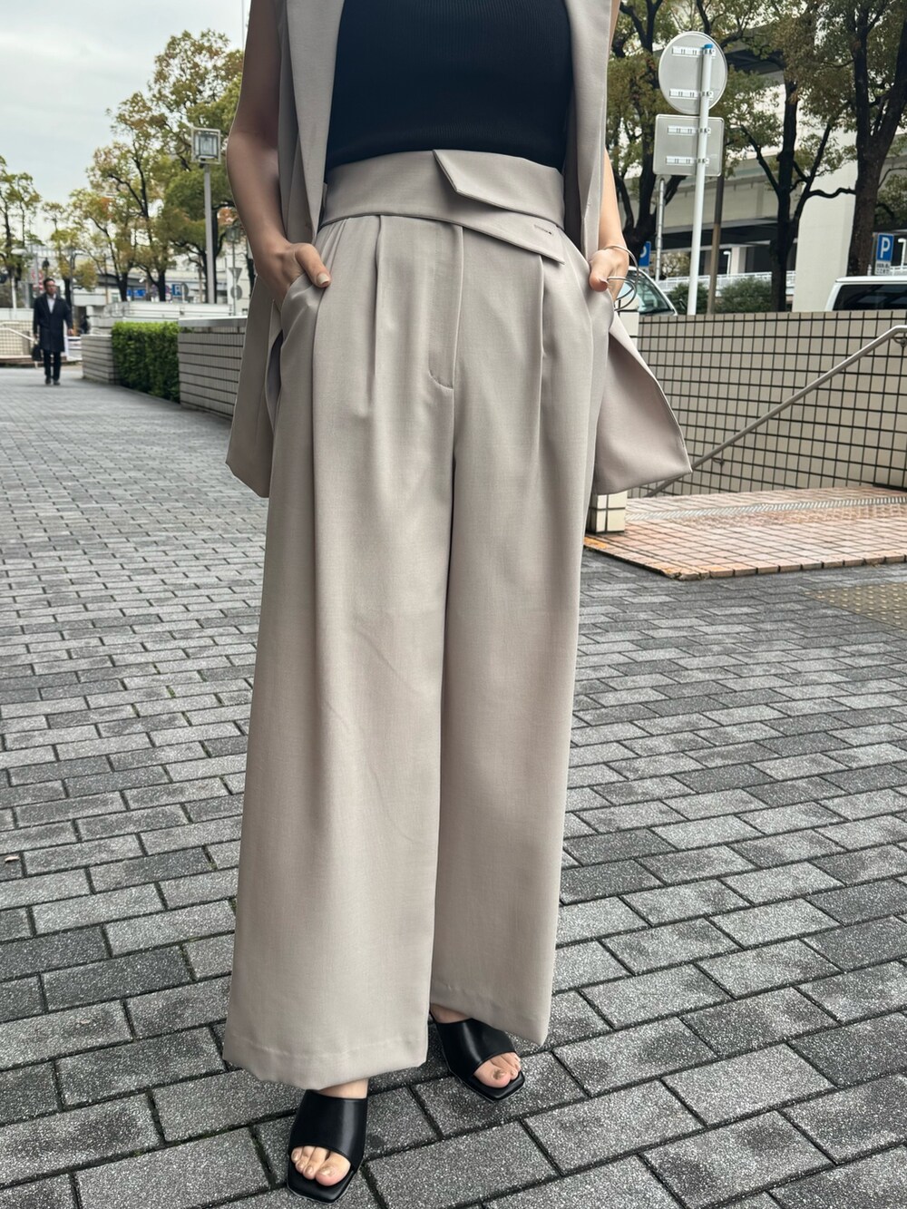 ベージュ系のその他パンツ、ベージュ系のベスト、ブラック系のサンダルを着用したレディースの春コーディネートの5枚目の写真
