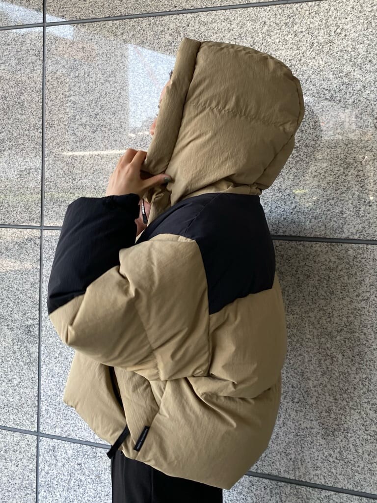 ブラック系のその他パンツ、ベージュ系のダウンジャケット/コート、ブラック系のブーツを着用したレディースの秋コーディネートの7枚目の写真