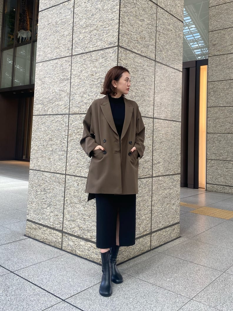 ブラック系のニット/セーター、ブラック系のスカート、ベージュ系のテーラードジャケットを着用したレディースの秋コーディネートの2枚目の写真