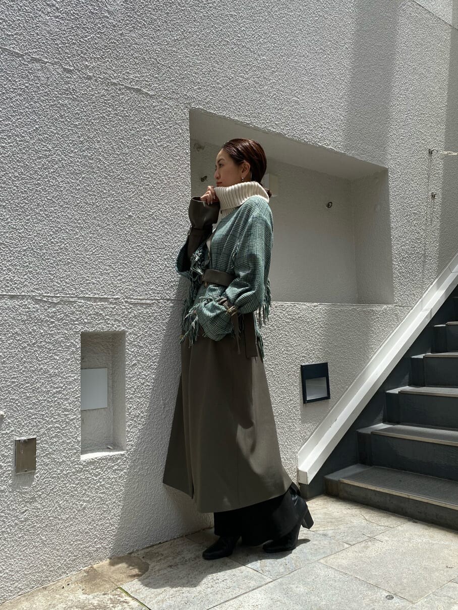 ベージュ系のトレンチコートを着用したレディースの夏コーディネートの2枚目の写真