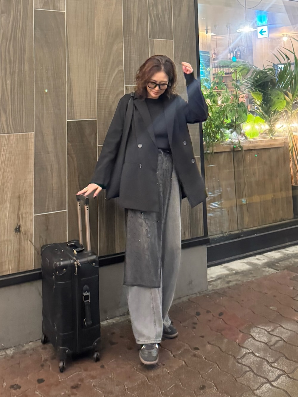 ブラック系のテーラードジャケット、ブラック系のデニムパンツ、ブラック系のストール/ショールを着用したレディースの春コーディネートの3枚目の写真