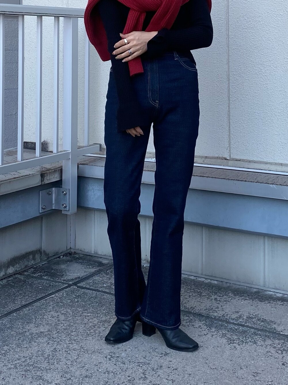 ブルー系のデニムパンツ、レッド系のニット/セーターを着用したレディースの冬コーディネートの4枚目の写真