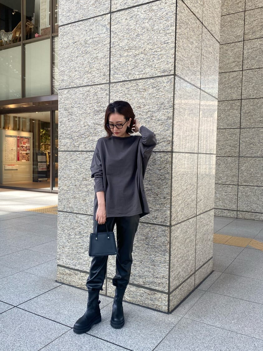 ブラック系のブーツ、ブラック系のハンドバッグ、グレー系のTシャツ/カットソーを着用したレディースの秋コーディネートの3枚目の写真