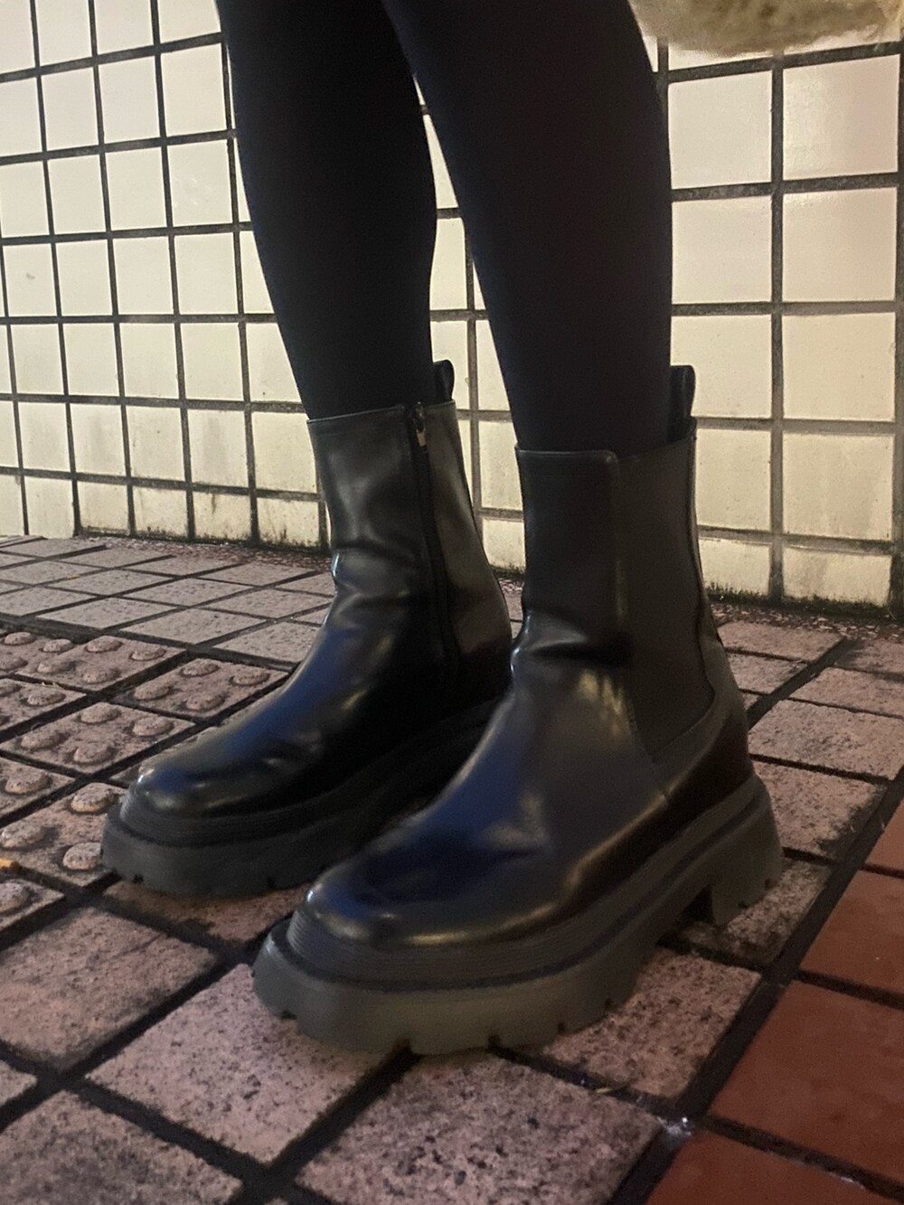 ホワイト系のブルゾン、ブラック系のブーツを着用したレディースの冬コーディネートの7枚目の写真