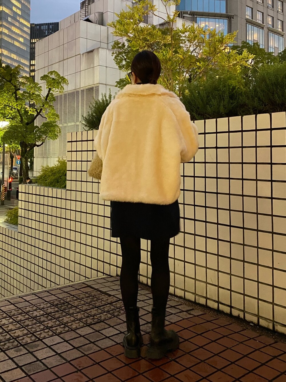 ホワイト系のブルゾン、ブラック系のブーツを着用したレディースの冬コーディネートの4枚目の写真