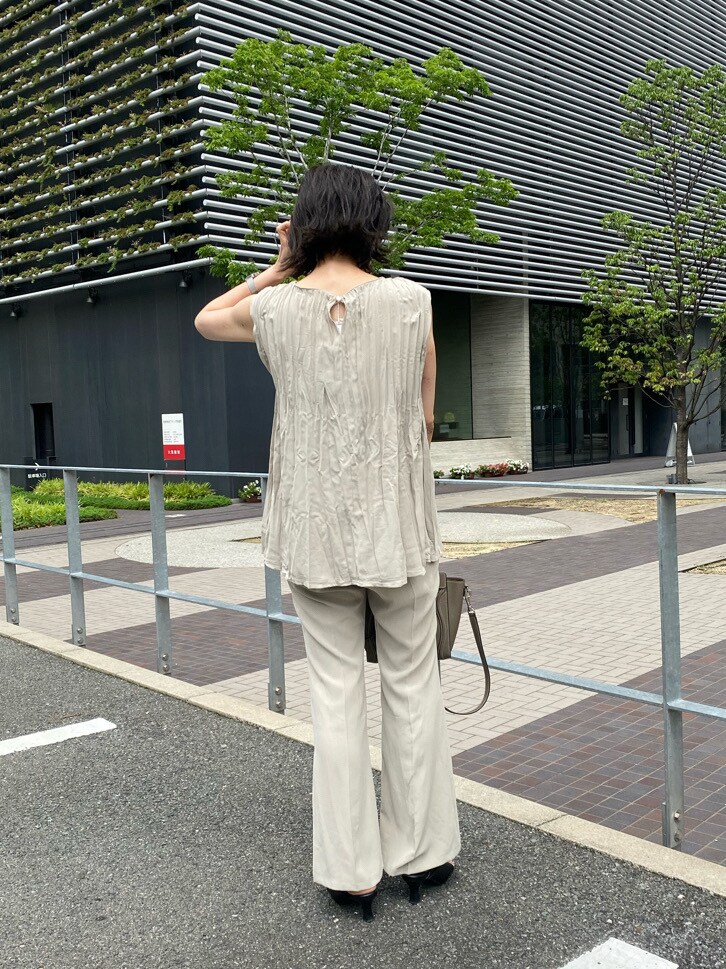 ベージュ系のシャツ/ブラウス、ブラック系のサンダル、ベージュ系のスラックスを着用したレディースの夏コーディネートの3枚目の写真