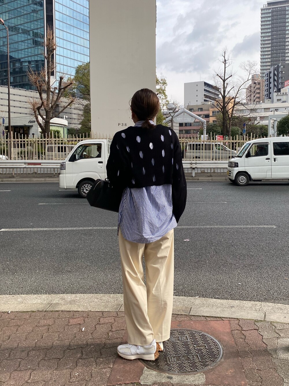 ブラック系のニット/セーター、ブラック系のハンドバッグを着用したレディースの冬コーディネートの3枚目の写真