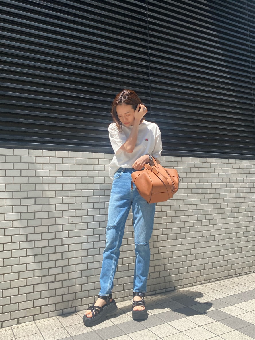 ブルー系のデニムパンツ、ブラック系のサンダル、その他のTシャツ/カットソーを着用したレディースの春コーディネートの3枚目の写真