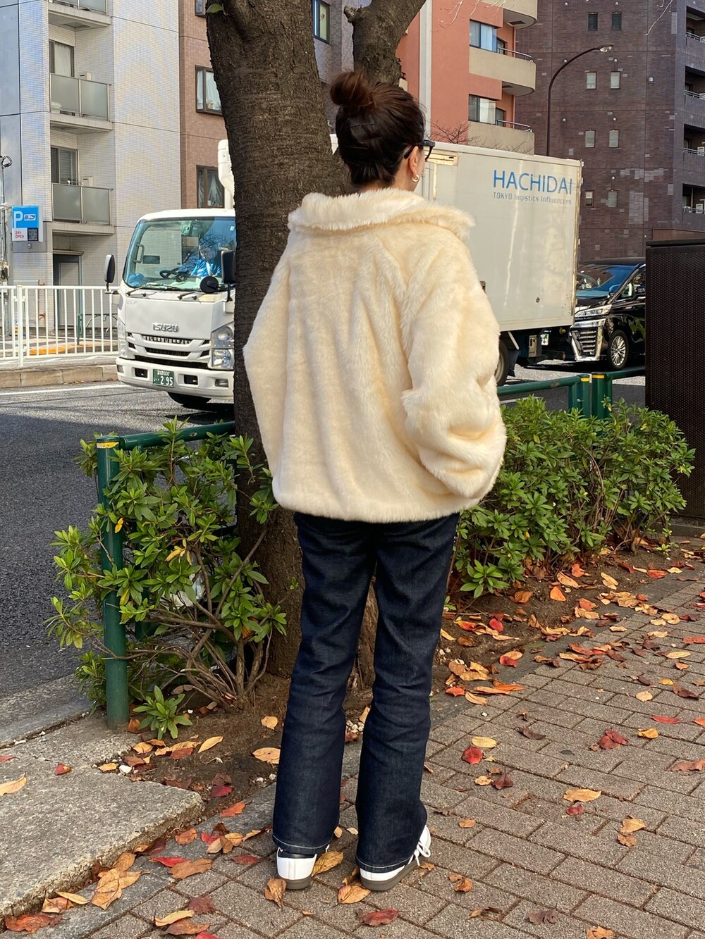 ホワイト系のブルゾン、ブルー系のデニムパンツを着用したレディースの冬コーディネートの3枚目の写真