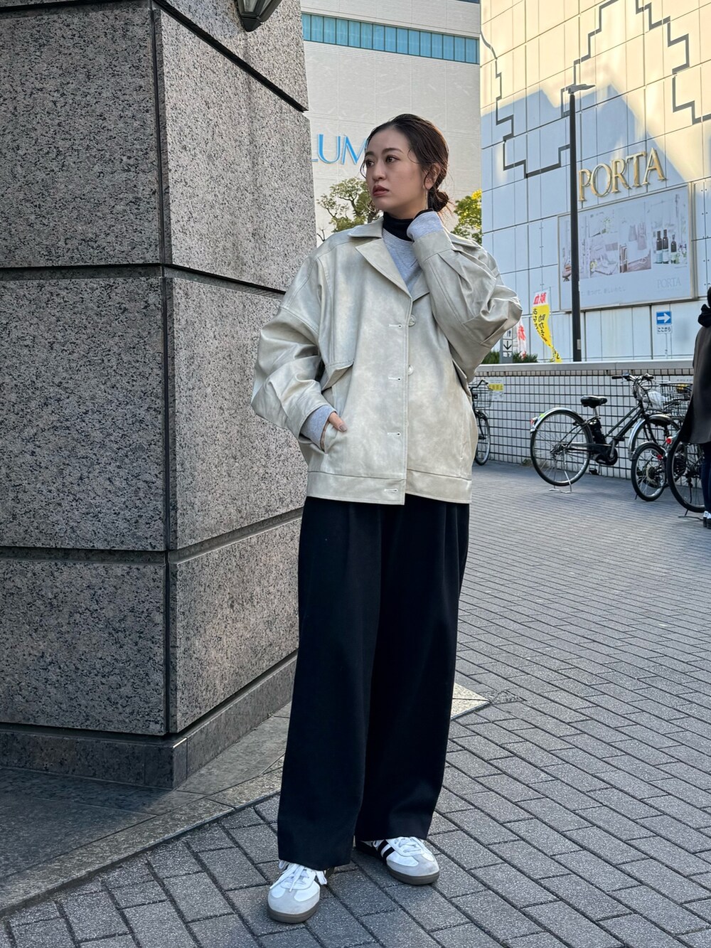 ホワイト系のブルゾン、グリーン系のキャップを着用したレディースの冬コーディネートの3枚目の写真