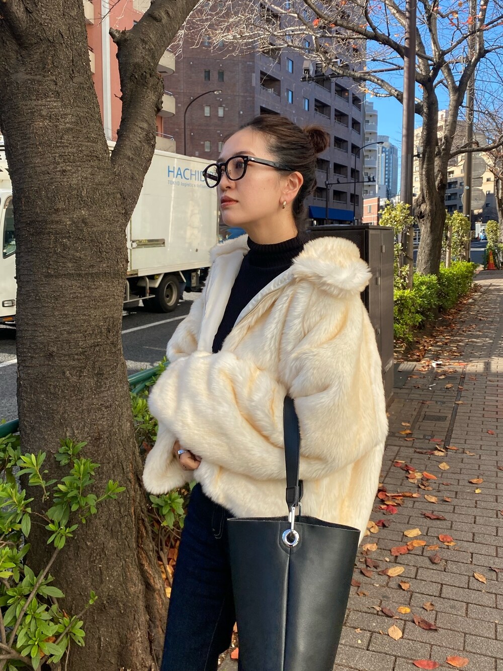 ホワイト系のブルゾン、ブルー系のデニムパンツを着用したレディースの冬コーディネートの4枚目の写真