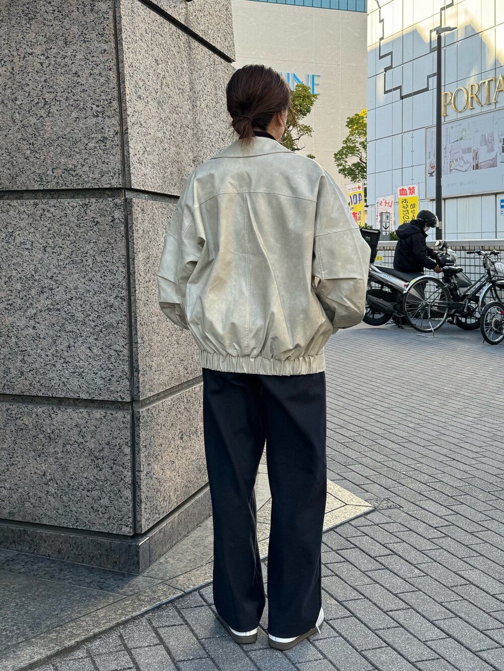 ホワイト系のブルゾン、グリーン系のキャップを着用したレディースの冬コーディネートの4枚目の写真