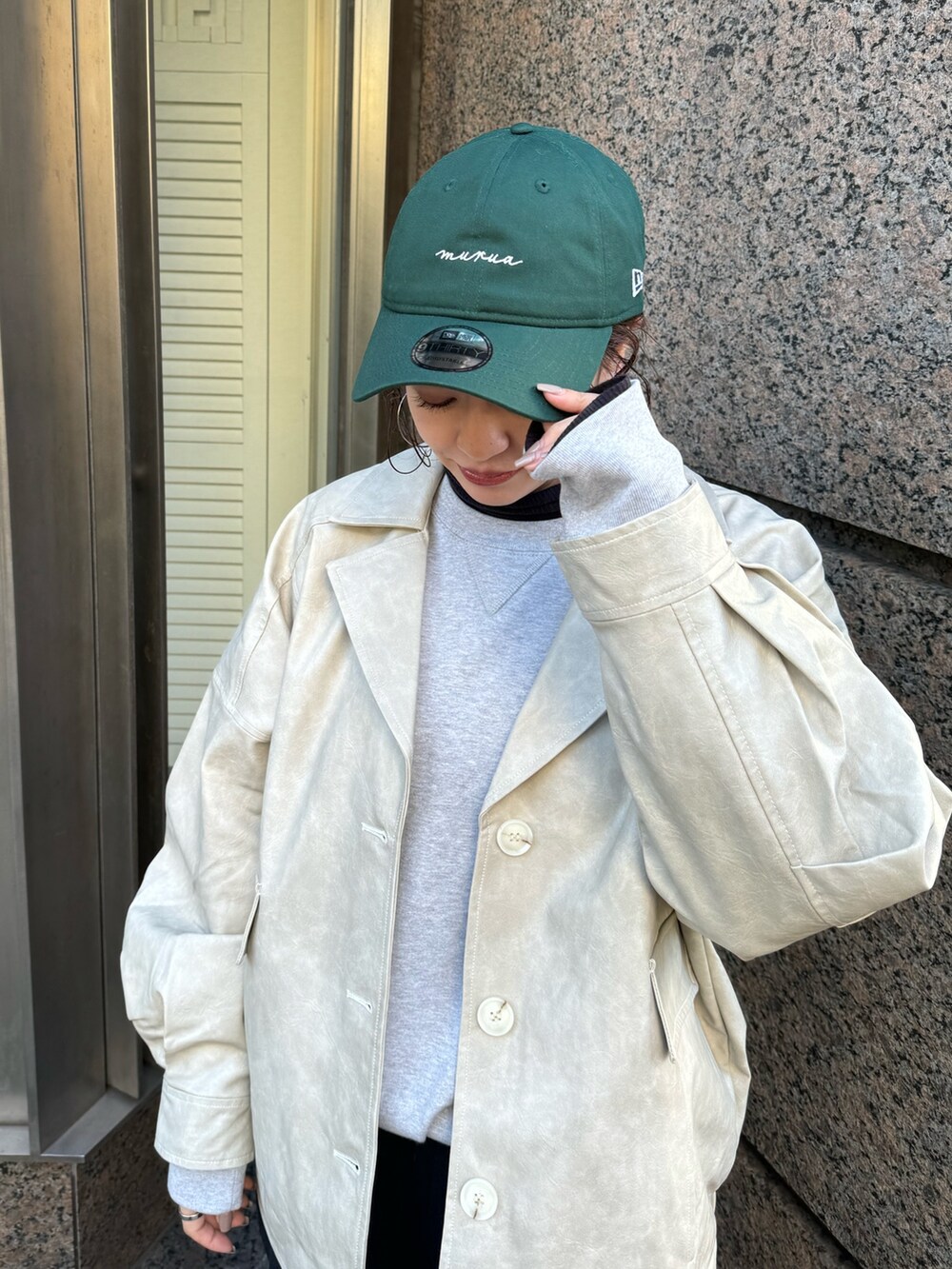 ホワイト系のブルゾン、グリーン系のキャップを着用したレディースの冬コーディネートの6枚目の写真