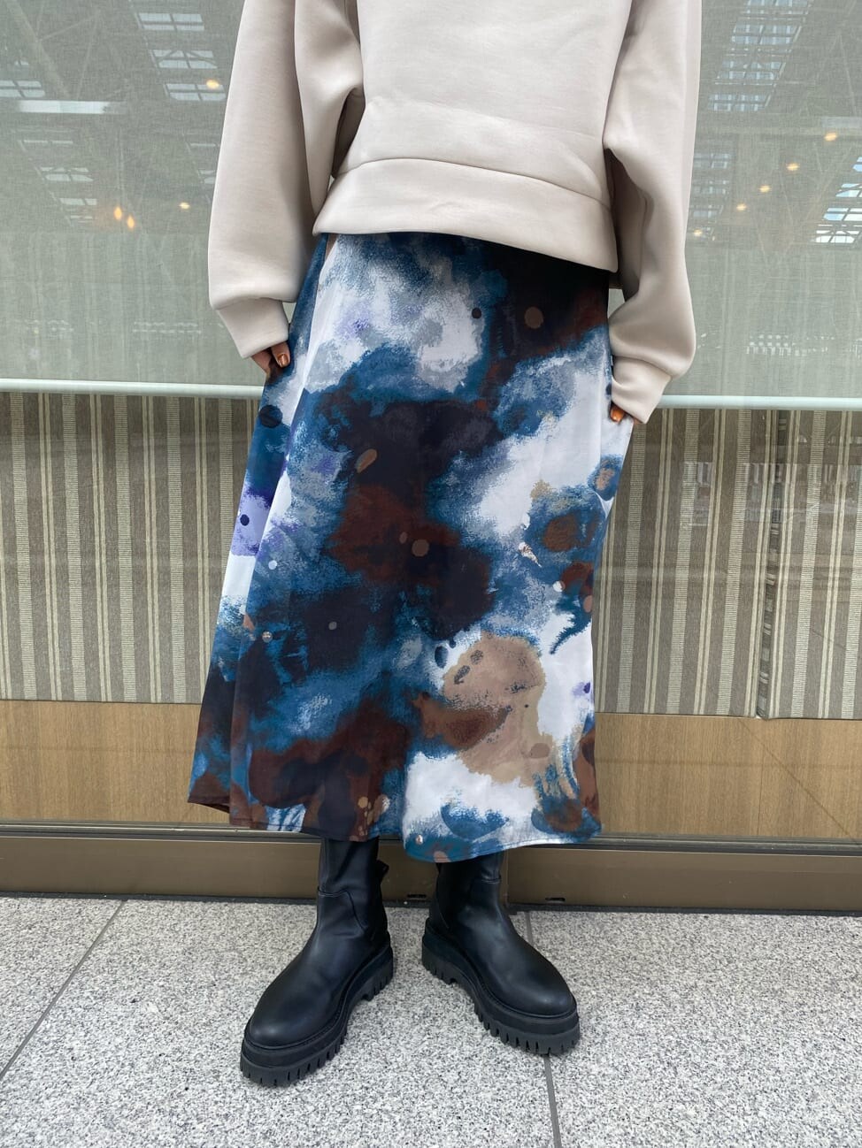 ブルー系のスカート、ブラック系のブーツ、ホワイト系のパーカーを着用したレディースの秋コーディネートの5枚目の写真