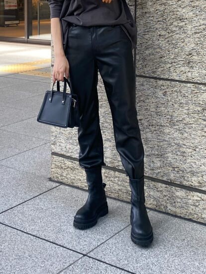 ブラック系のブーツ、ブラック系のハンドバッグ、グレー系のTシャツ/カットソーを着用したレディースの秋コーディネートの5枚目の写真