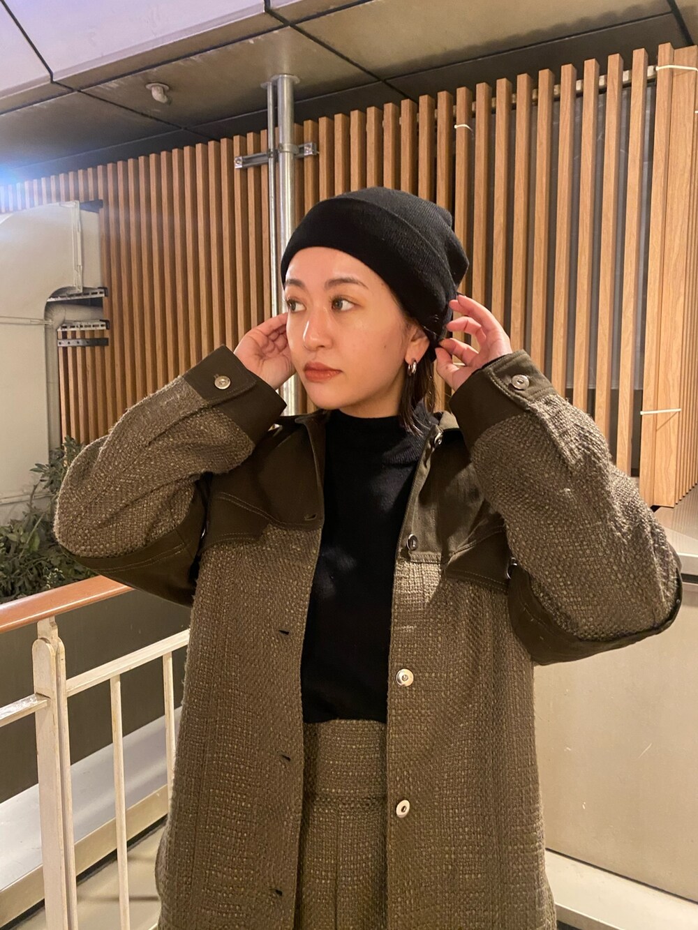 グリーン系のブルゾン、グリーン系のカーゴパンツ、ブラック系のニット/セーターを着用したレディースの冬コーディネートの4枚目の写真