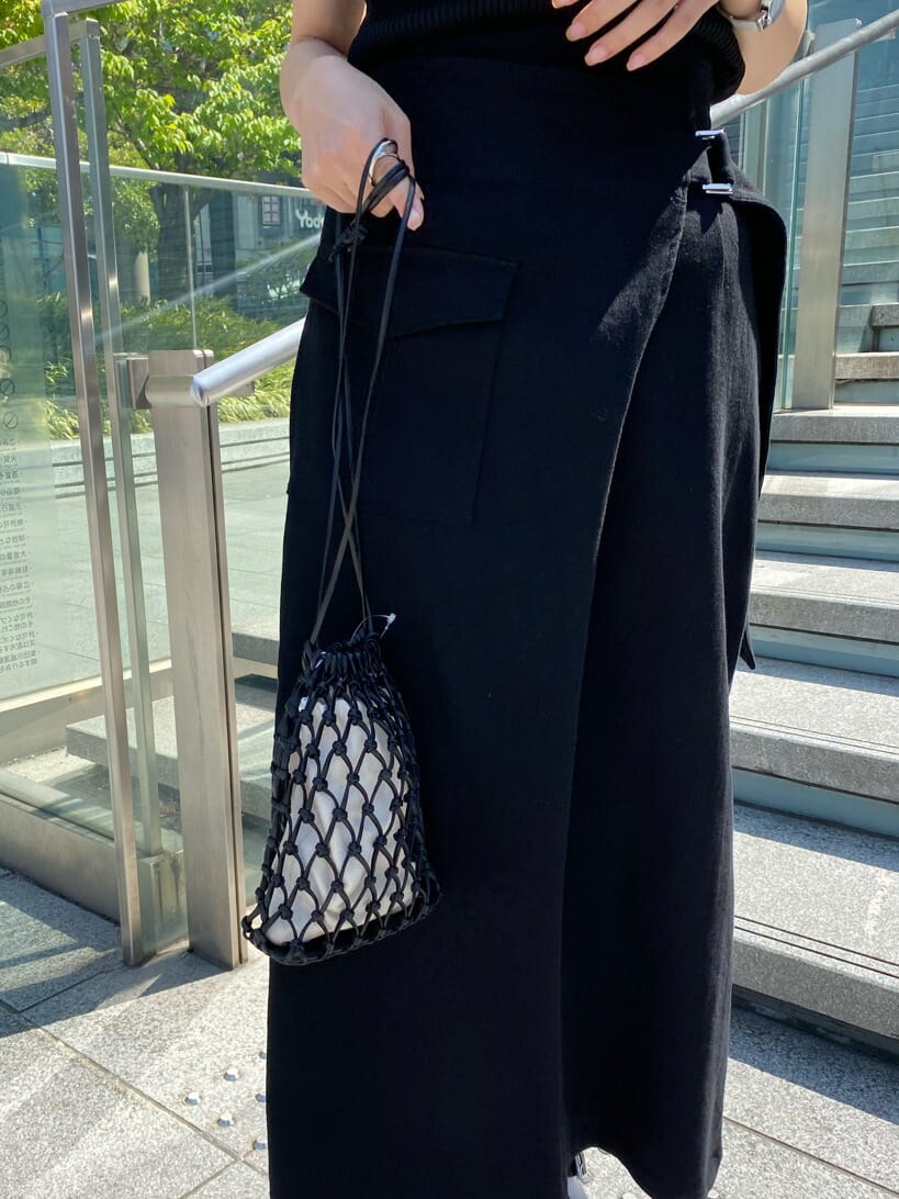 ブラック系のハンドバッグ、ブラック系のタンクトップ、グレー系のシャツ/ブラウスを着用したレディースの春コーディネートの9枚目の写真