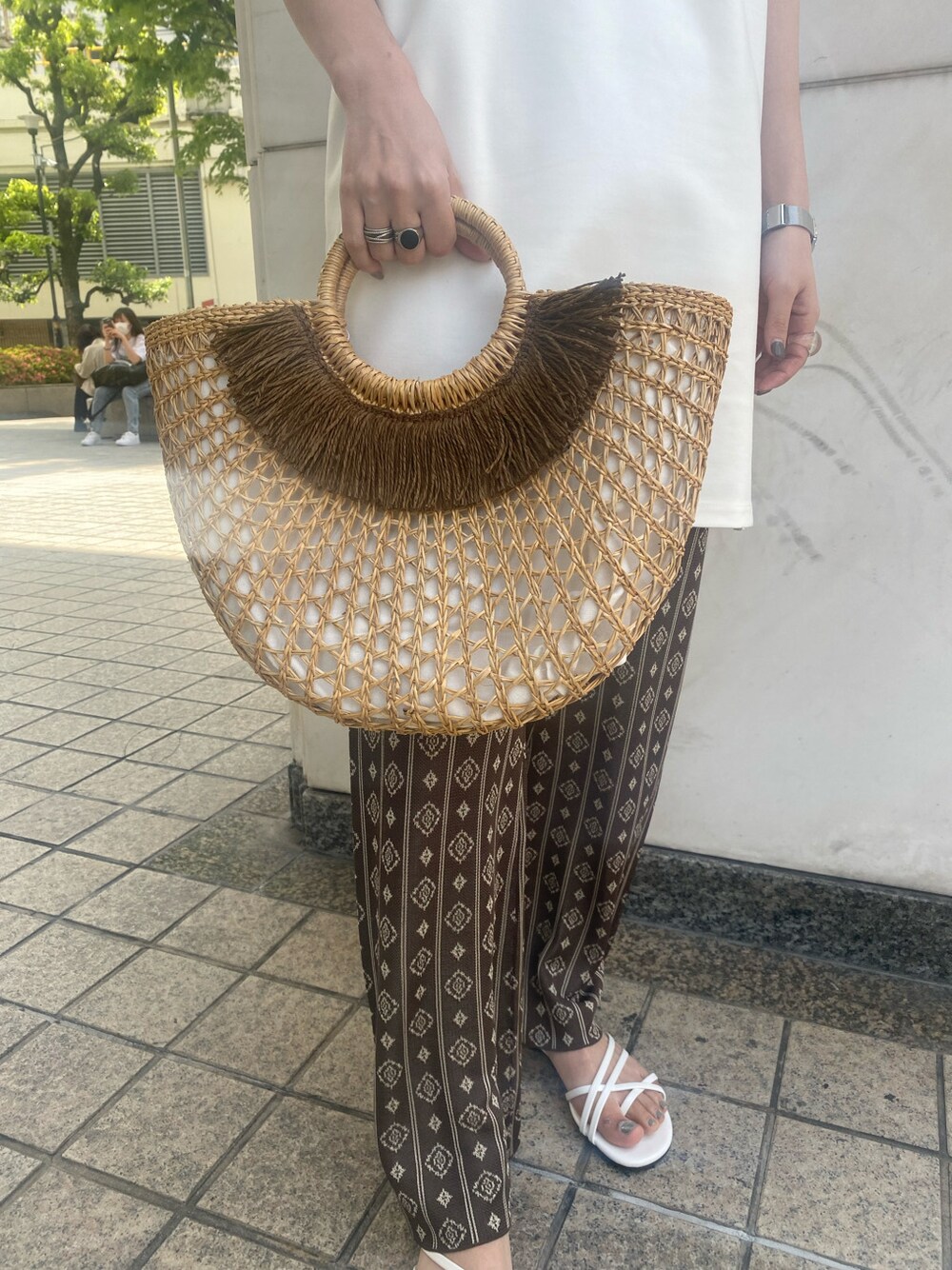 ホワイト系のワンピース、ブラウン系のその他パンツ、ベージュ系のかごバッグを着用したレディースの春コーディネートの5枚目の写真