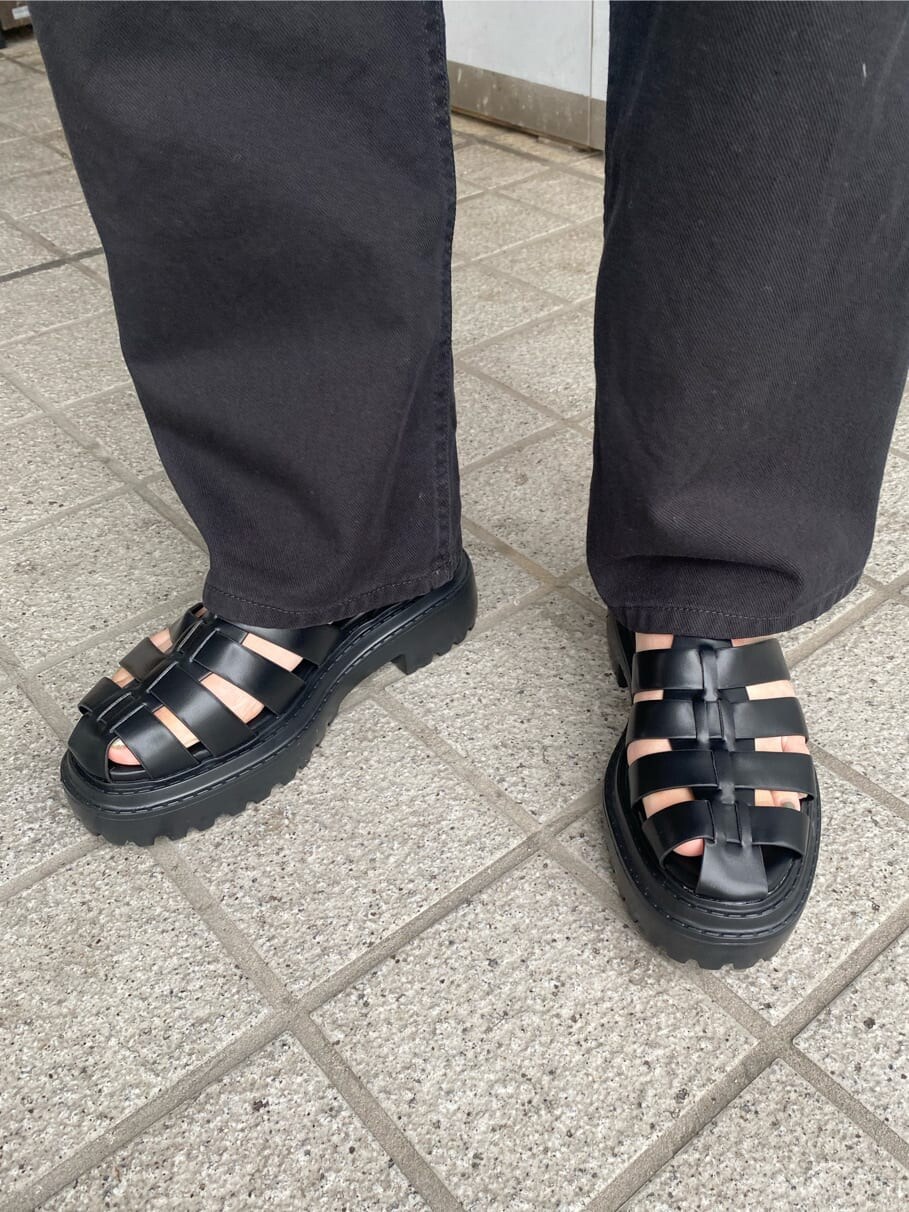 ブラック系のテーラードジャケット、ブラック系のデニムパンツ、ブラック系のサンダルを着用したレディースの春コーディネートの9枚目の写真