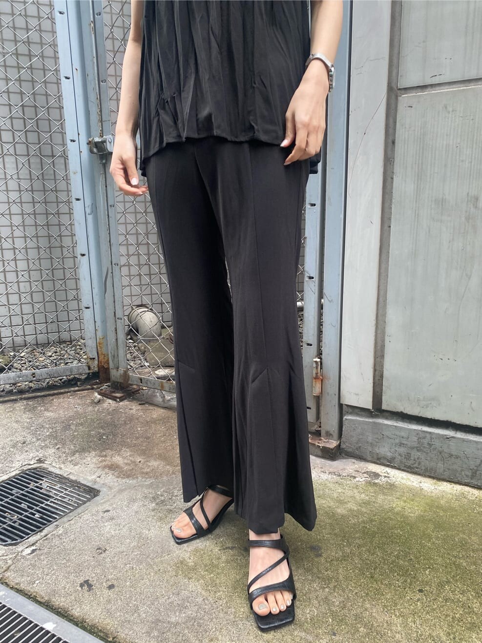 ブラック系のサンダル、ブラック系のシャツ/ブラウス、ブラック系のスラックスを着用したレディースの夏コーディネートの5枚目の写真