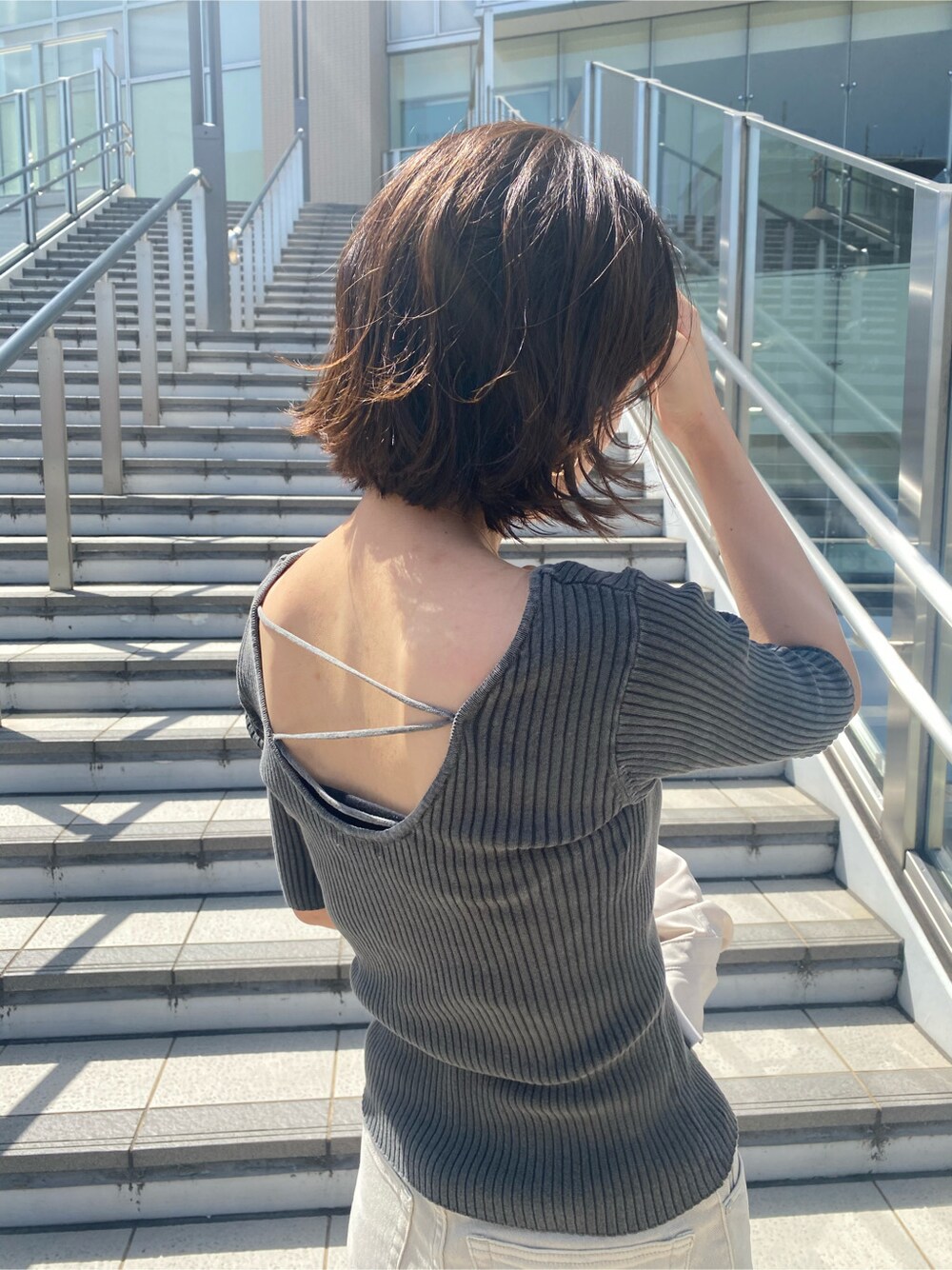 ホワイト系のシャツ/ブラウス、グレー系のその他パンツ、ブラック系のニット/セーターを着用したレディースの春コーディネートの5枚目の写真