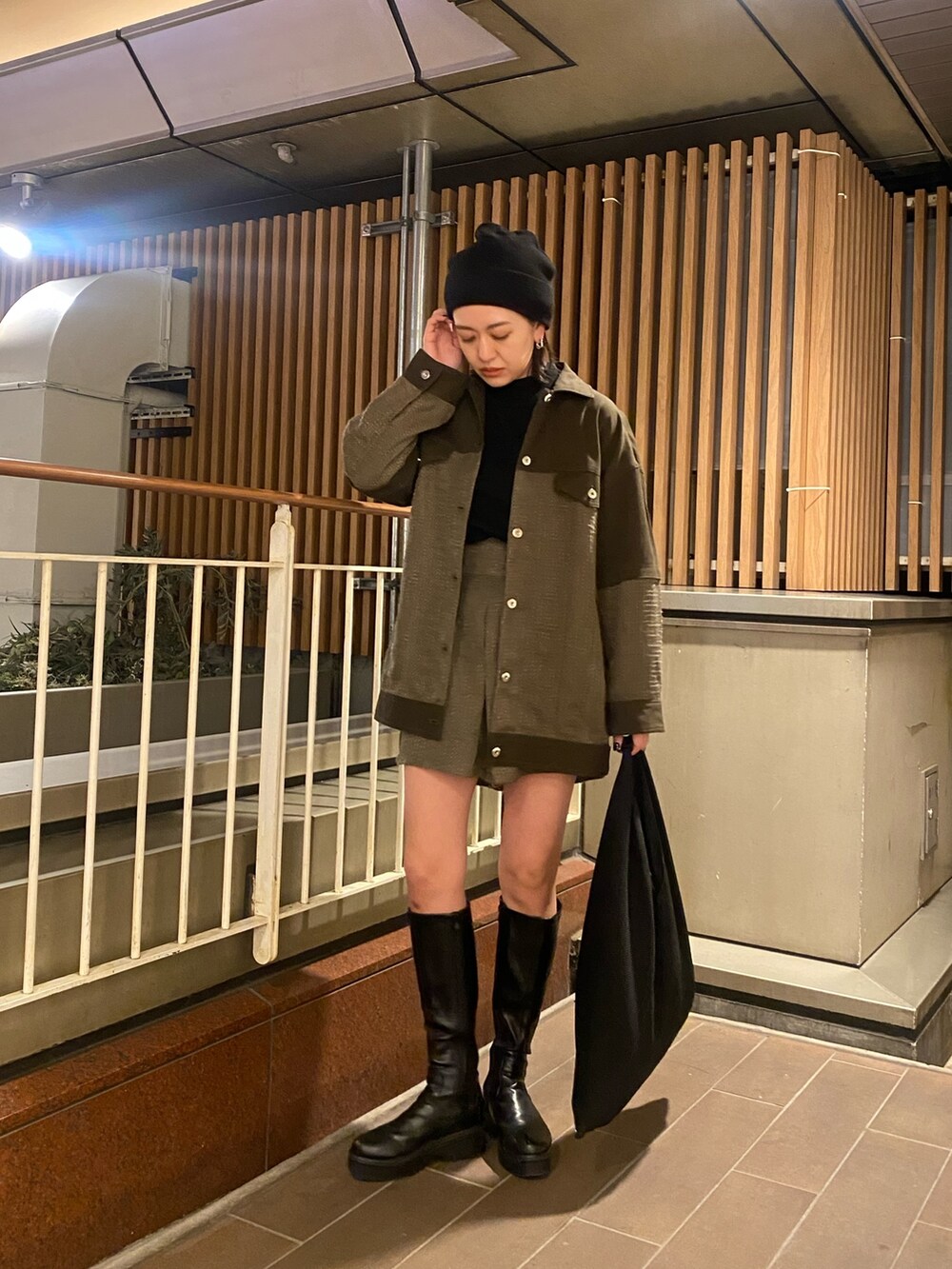 グリーン系のブルゾン、グリーン系のカーゴパンツ、ブラック系のニット/セーターを着用したレディースの冬コーディネートの2枚目の写真