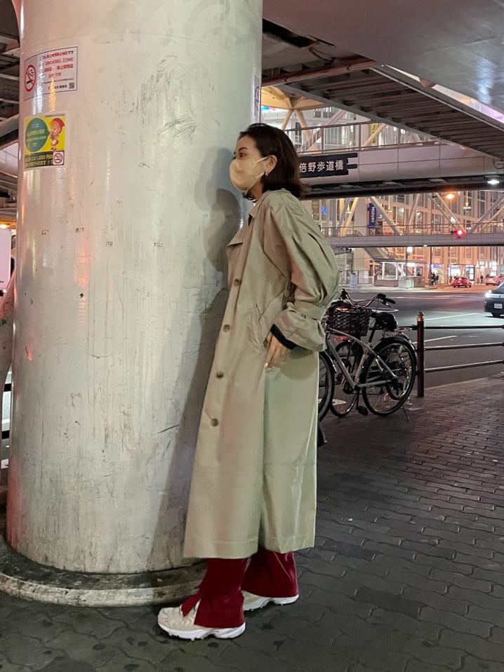 ベージュ系のトレンチコート、ブラック系のTシャツ/カットソー、シルバー系のピアス（両耳用）を着用したレディースの春コーディネートの4枚目の写真