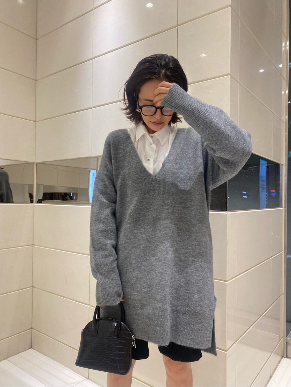 ブラック系のハンドバッグ、グレー系のニット/セーターを着用したレディースの秋コーディネートの2枚目の写真