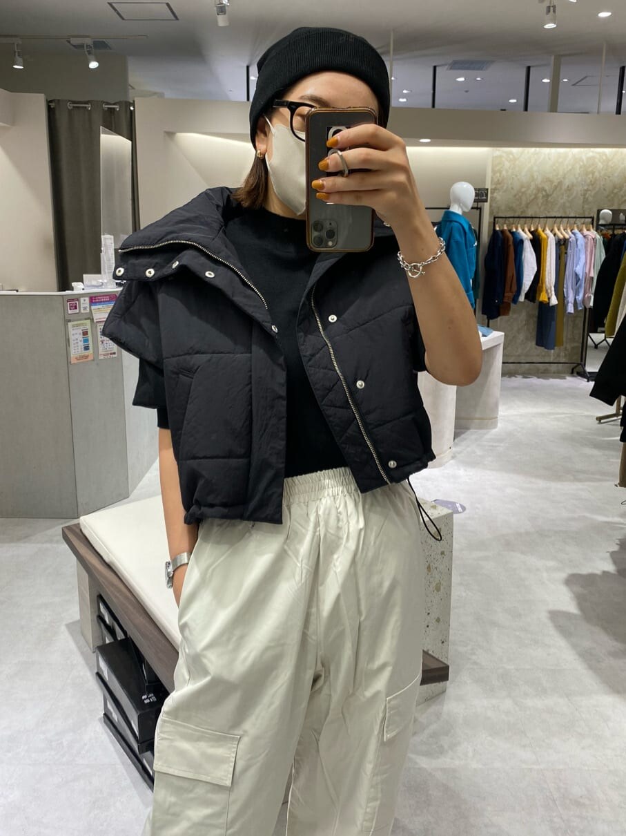 ブラック系のダウンベスト、ブラック系のニット/セーター、ホワイト系のカーゴパンツを着用したレディースの秋コーディネートの3枚目の写真