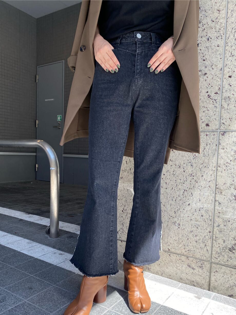 ベージュ系のテーラードジャケット、ブラック系のニット/セーター、ブラック系のデニムパンツを着用したレディースの秋コーディネートの4枚目の写真