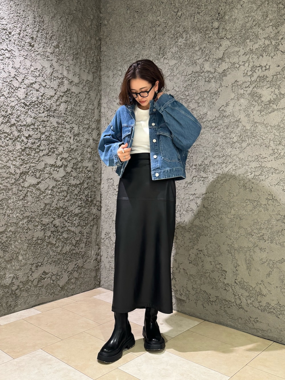 ブラック系のブーツ、ブルー系のデニムジャケットを着用したレディースの冬コーディネートの2枚目の写真