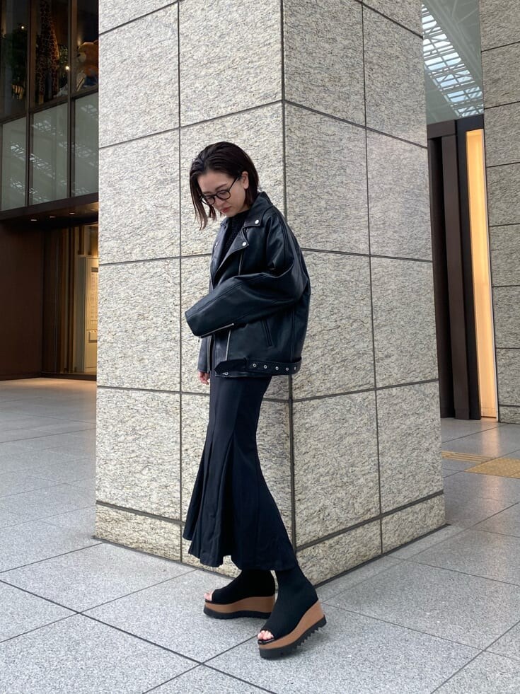 ブラック系のライダースジャケット、ブラック系のスカート、ブラック系のブーツを着用したレディースの冬コーディネートの2枚目の写真